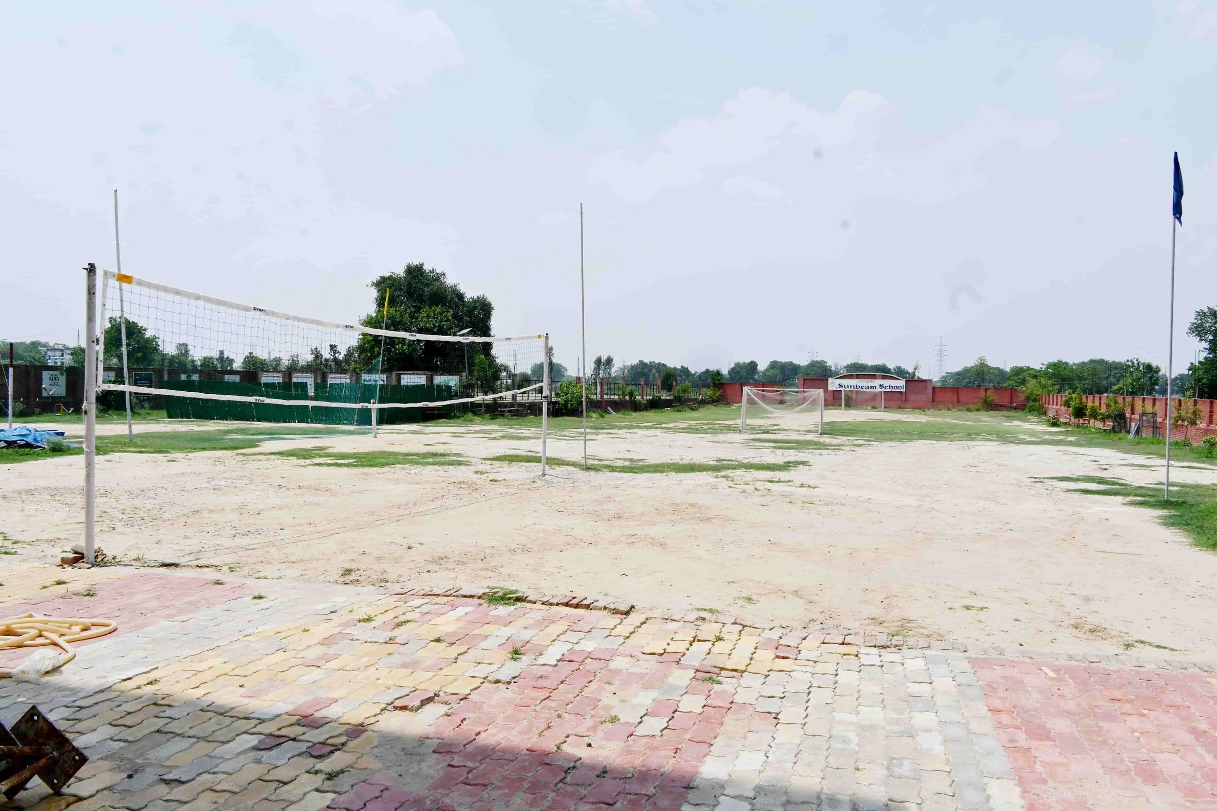 The JOSH ground at Sunbeam School Ballia, the volleyball court marked out and the school's name on the boundary wall